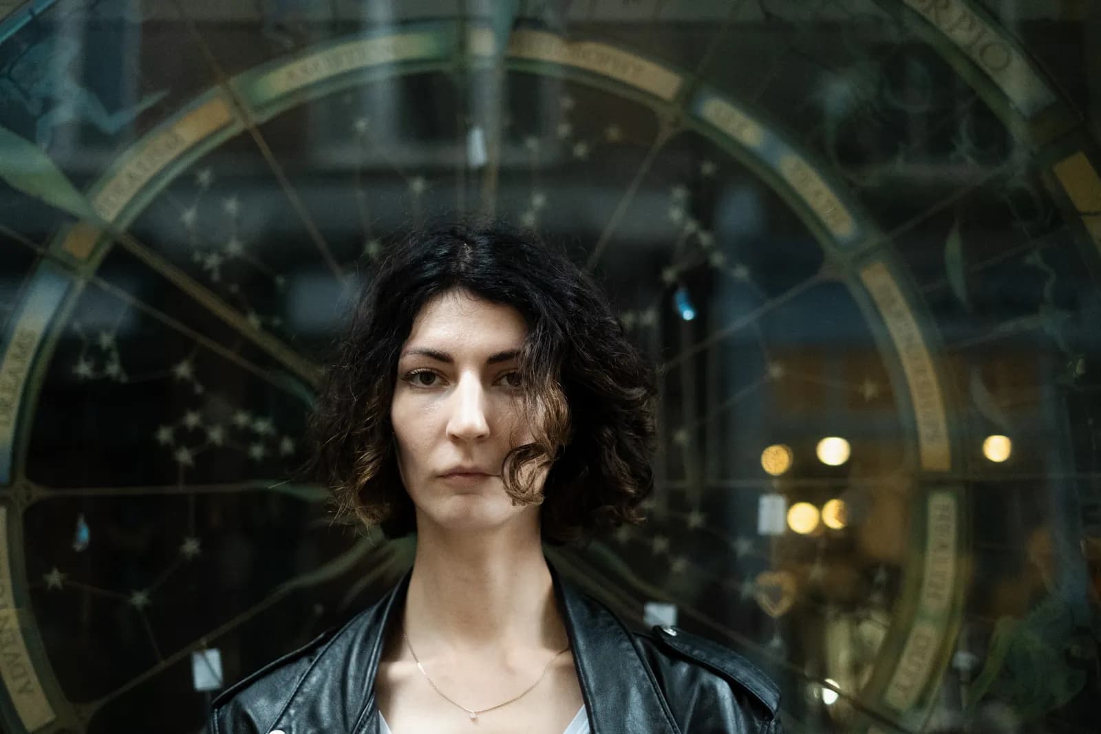 Musician in a leather jacket in front of an astronomical clock shop window