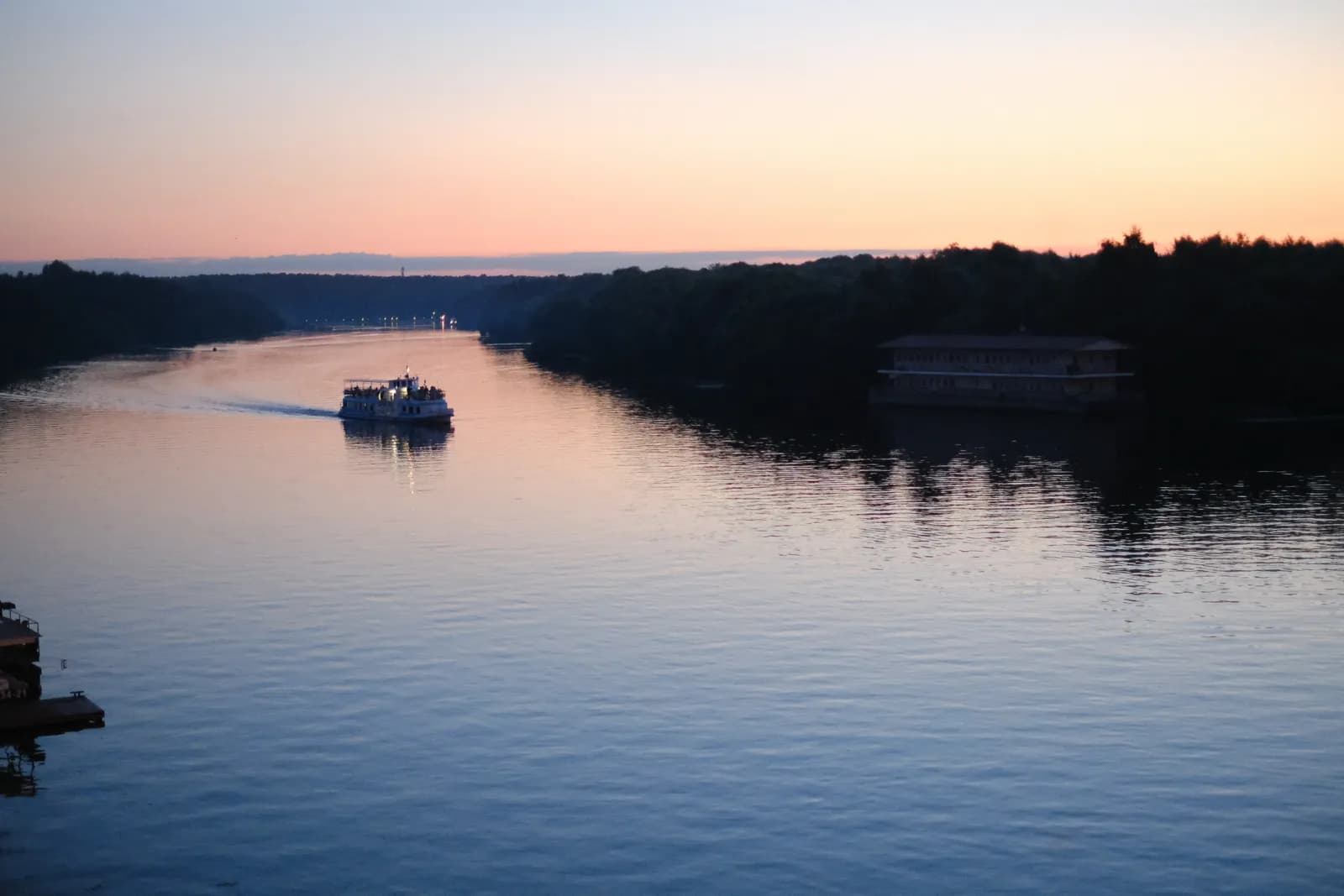 The river at sunset from the bridge, a pleasure boat heading up the channel