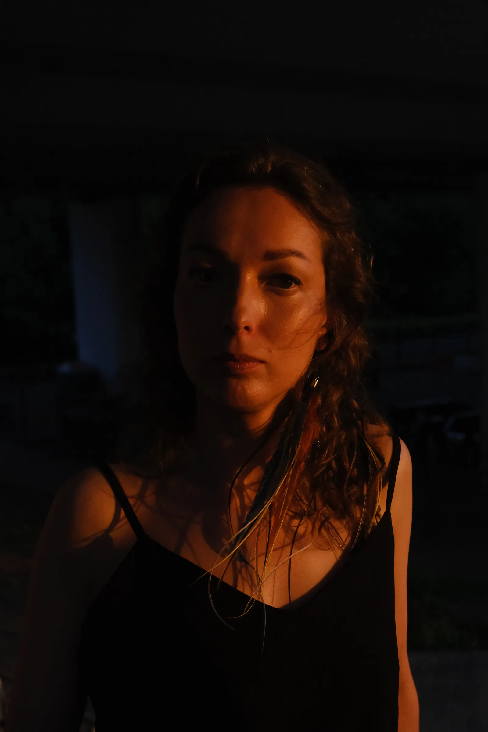Dusk portrait, wet strands on her shoulders, face lit by the afterglow